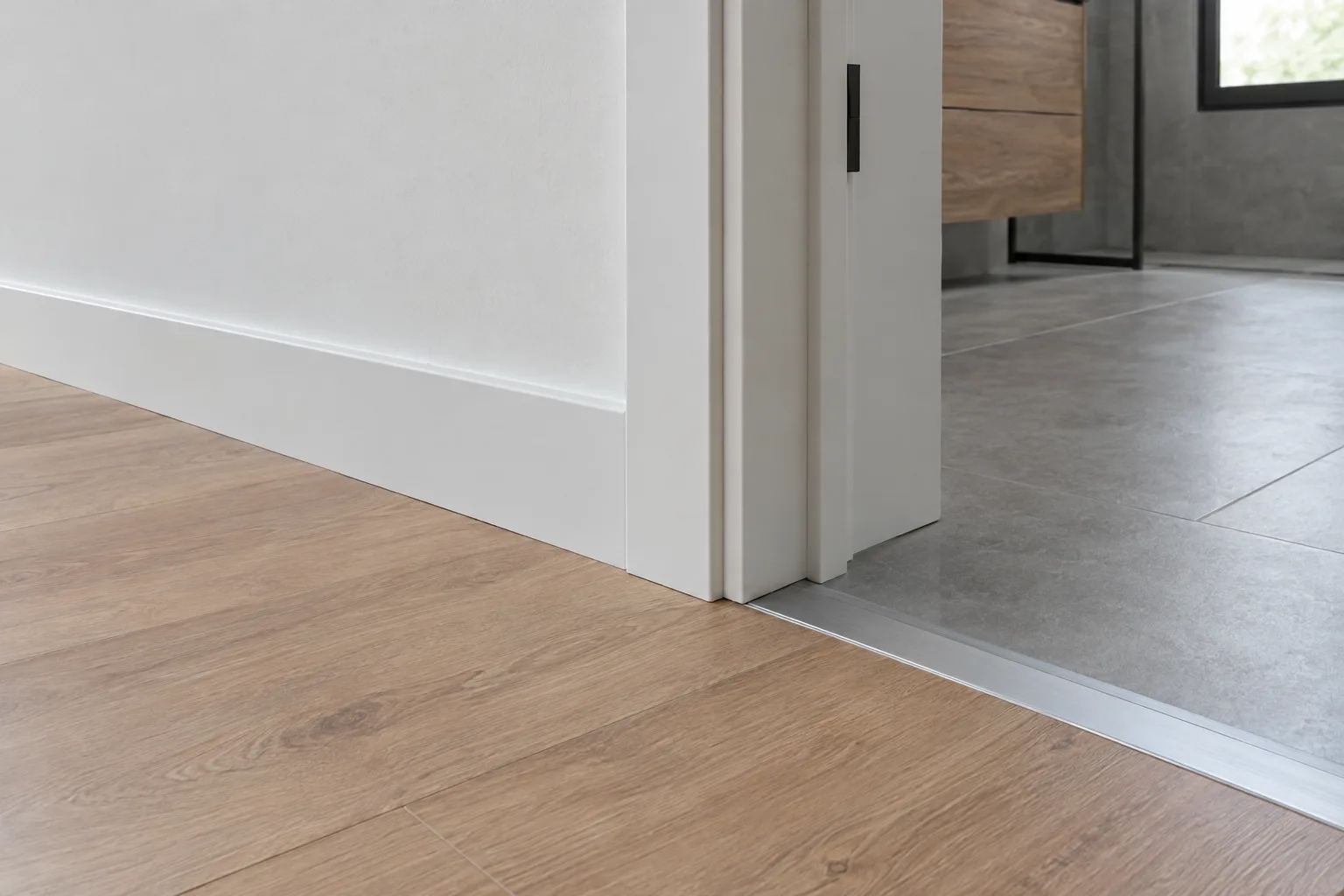 Encuentro entre suelo laminado y rodapié con perfil de transición